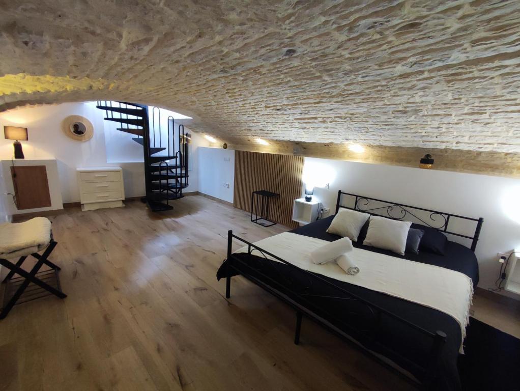 a bedroom with a bed and a stone wall at Le Reflet - Vue Rivière et Caractère in Dijon