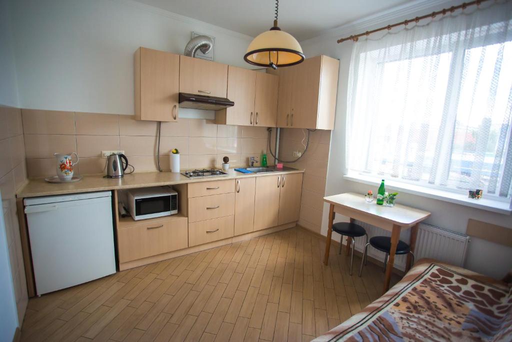 イヴァーノ・フランキーウシクにあるLike Home on Zaliznychnaのキッチン(木製キャビネット、小さなテーブル、テーブル付)