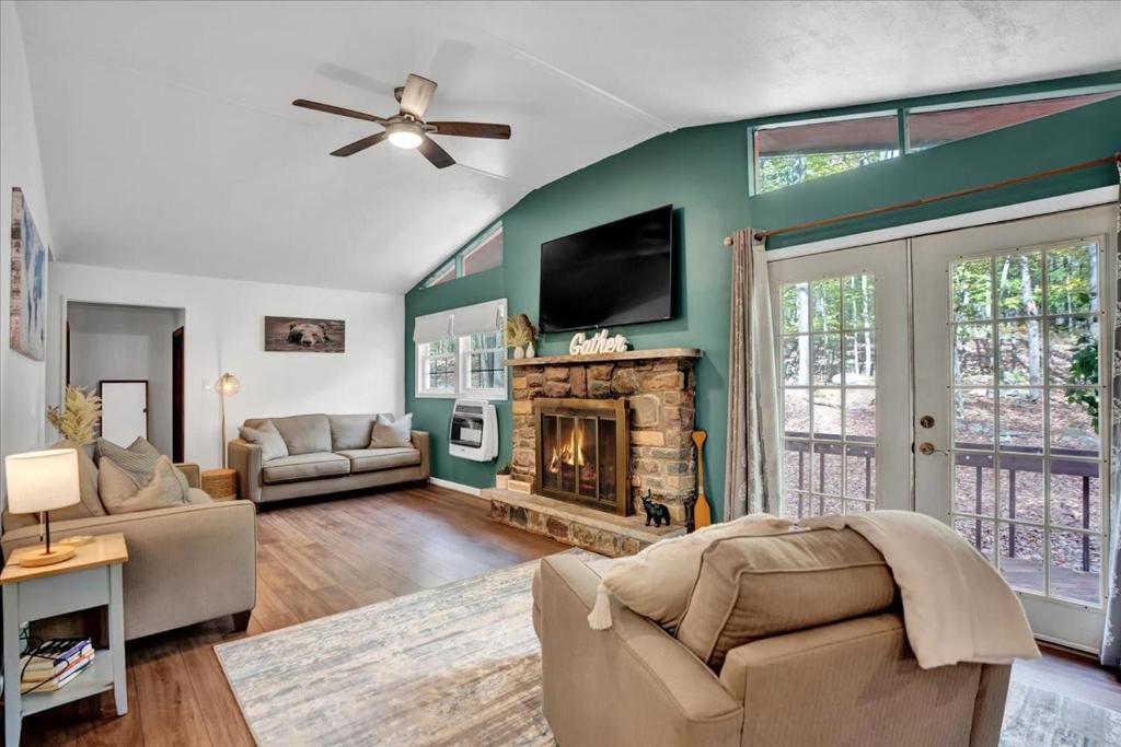 een woonkamer met een open haard en een flatscreen-tv bij Tranquil Trails Cottage Fire Pit Cozy 3BDR in Gouldsboro