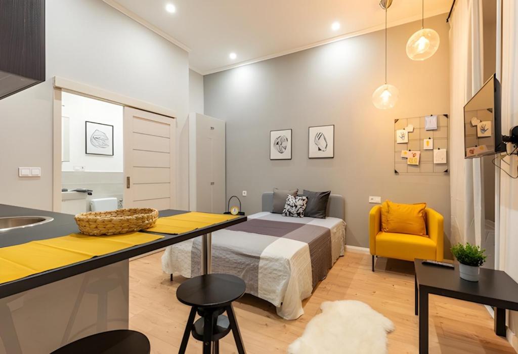 een slaapkamer met een bed en een gele stoel bij A57- Boutique Apartments, Best Location, by BQA in Boedapest