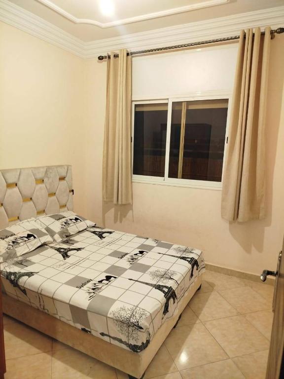 a bedroom with a bed and a window at A nice appartement a louer temara in Temara