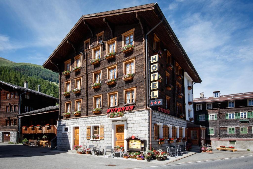 a building with a sign on the side of it at Hotel Nufenen in Ulrichen