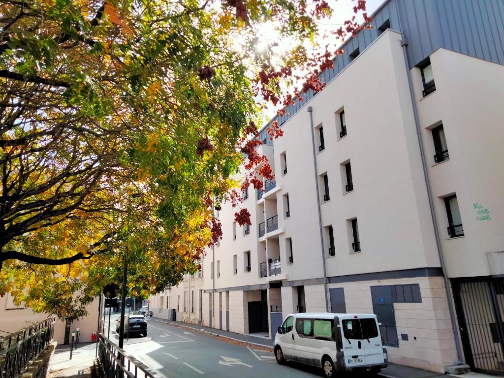 a white van parked in front of a white building at Chambre d'hôtes Coeur de Maine in Angers