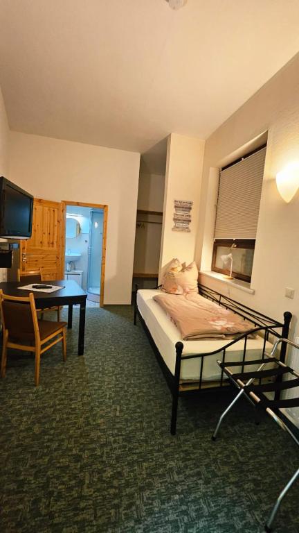 a room with a bed and a table and a desk at Burgblick in Nossen