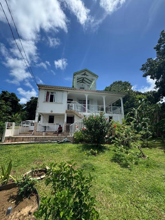 a white house with a yard in front of it at Villa du coeur in Deshaies