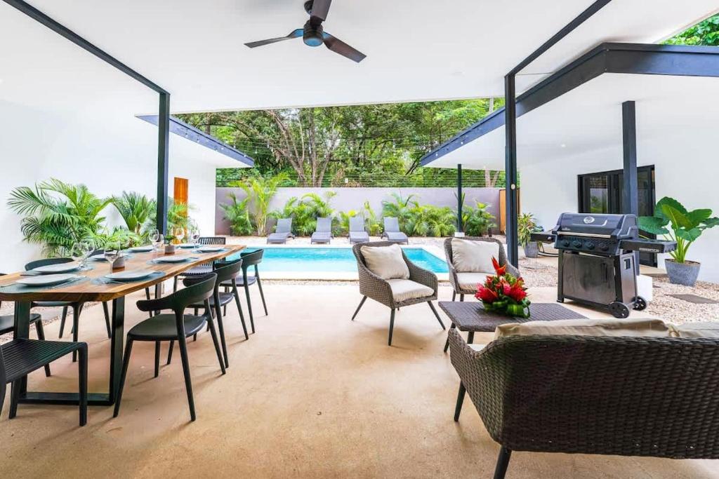 a patio with a table and chairs and a grill at Serenity Surf Villa in Playa Grande