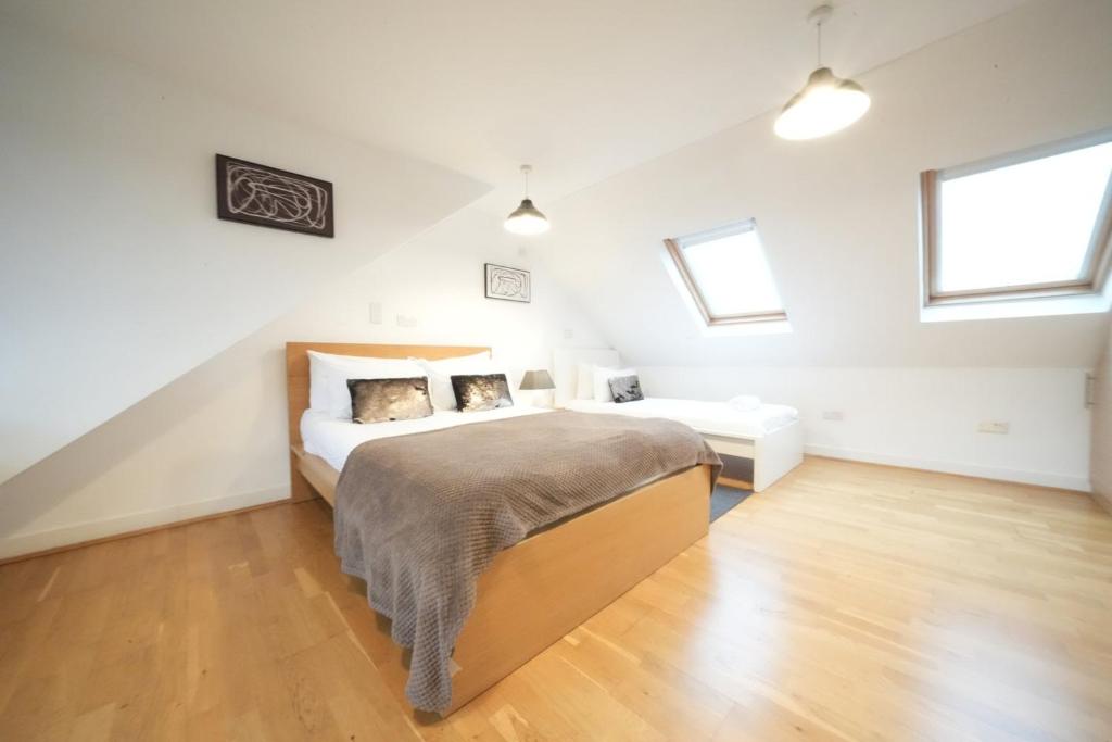 een slaapkamer met een bed en twee ramen bij Private Rooms-Private Bathrooms-Near Airport- CABIN CREW paradise in Harmondsworth