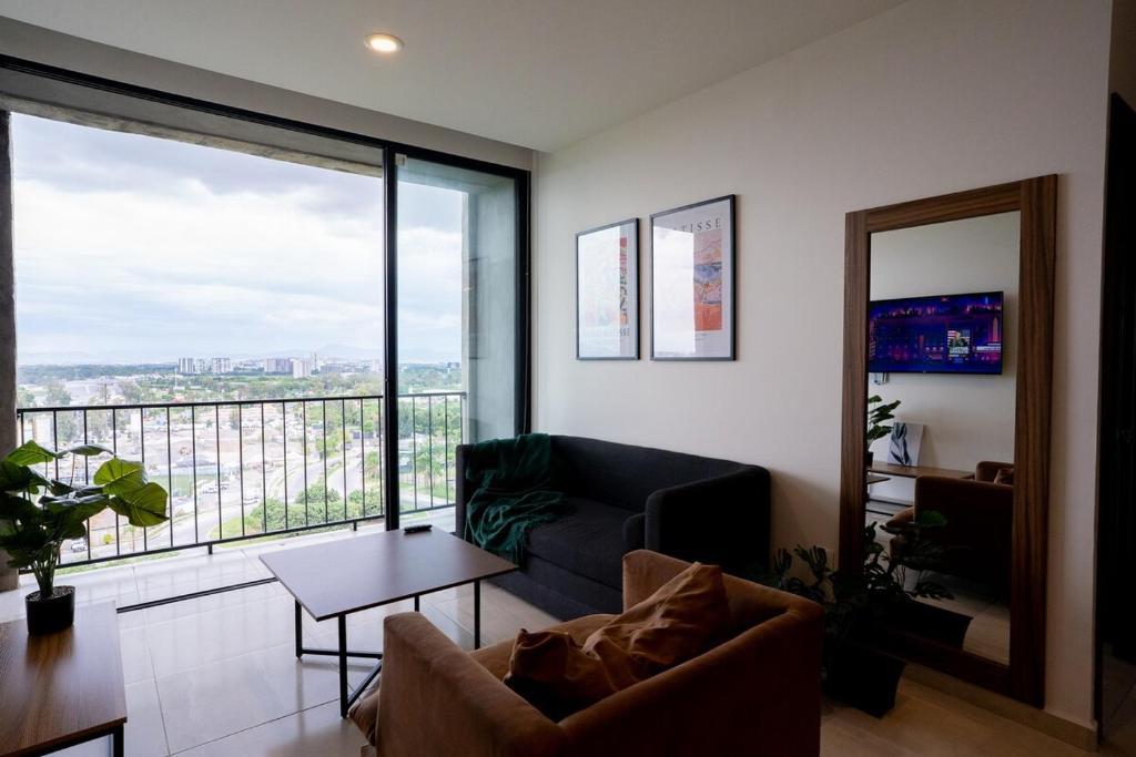 un salon avec un canapé et une grande fenêtre dans l'établissement Suite con Cama King y Queen, Wi-Fi Rápido y Amenidades Top, à Guadalajara
