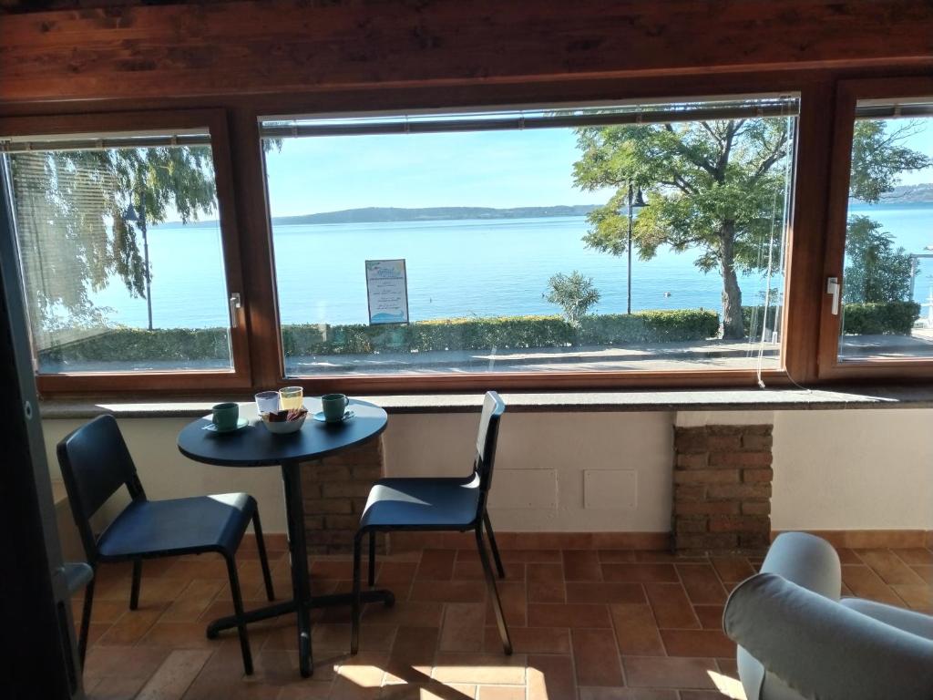 a room with a table and chairs and a large window at Villa Marini in Trevignano Romano