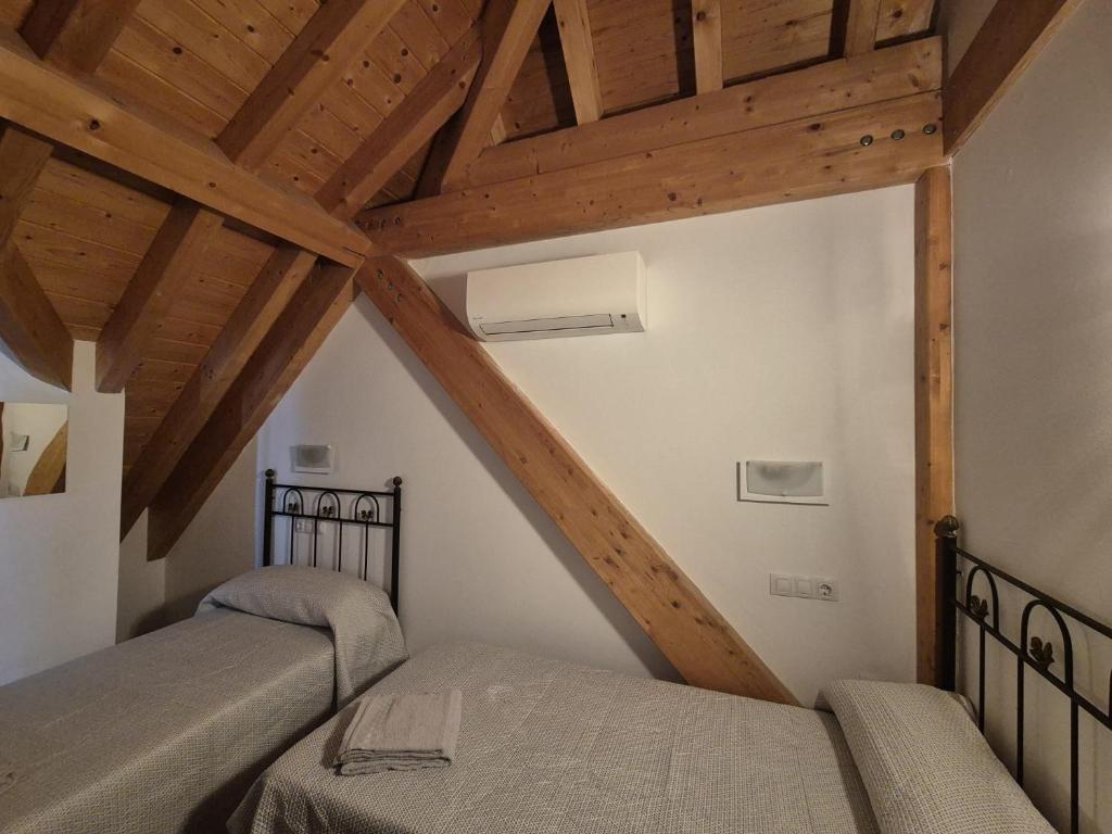 two beds in a attic room with wooden ceilings at NUEVO OCTUBRE 2025 Dúplex Sierra de Cazorla II in Arroyo Frio