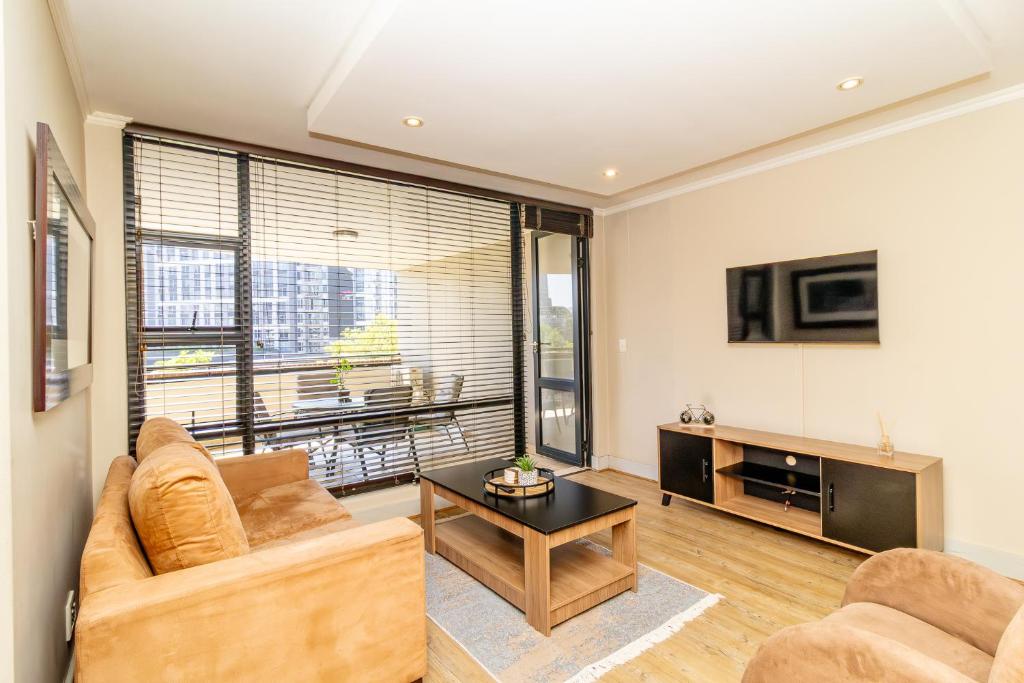 ein Wohnzimmer mit Sofa und Tisch in der Unterkunft Opulent Heights - Katherine Quay Sandton in Johannesburg