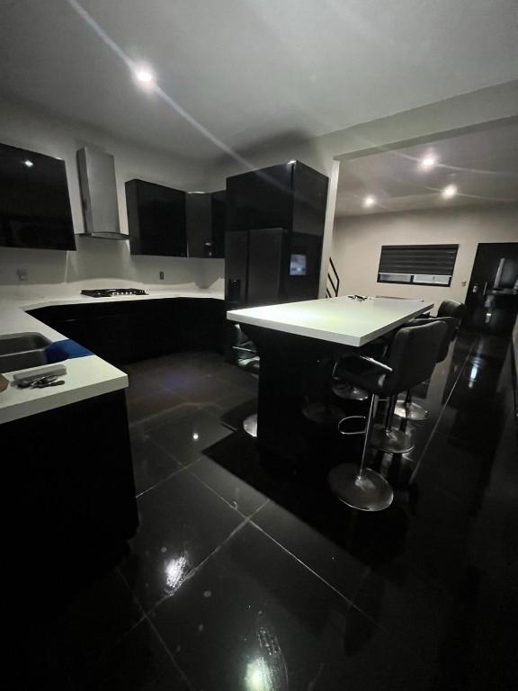a kitchen with a table and chairs in it at Tu casa en Rosarito en Familia in Rosarito Beach
