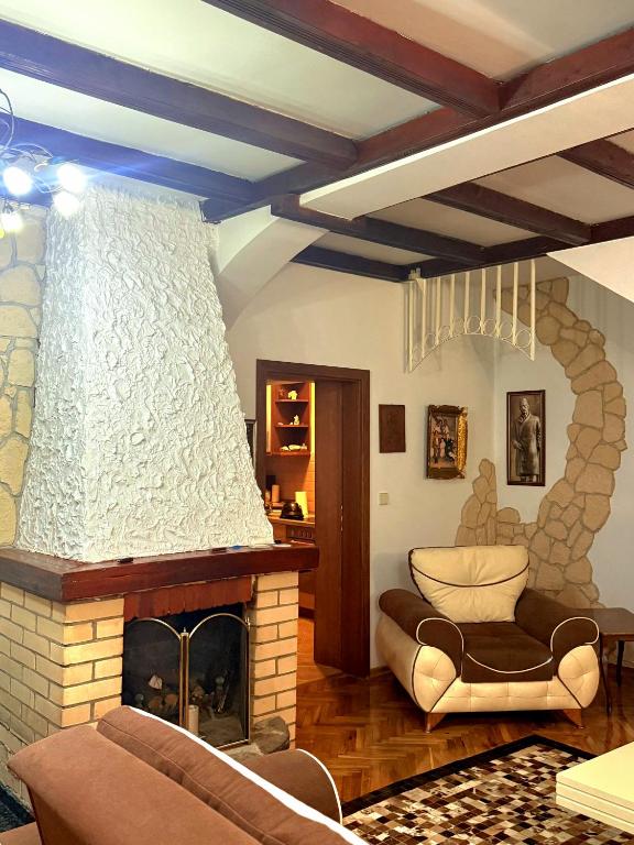 a living room with a fireplace and a couch at Serana Stays Classic Apartment with Private Bathroom, Free WiFi & Parking, Central Pejë in Peje