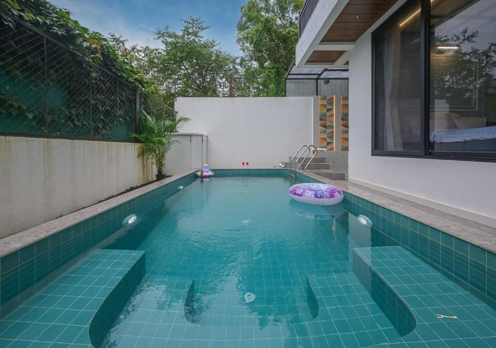 a swimming pool with a tub in a house at 5BHK Villa With Pool & Theater Room in Malavli
