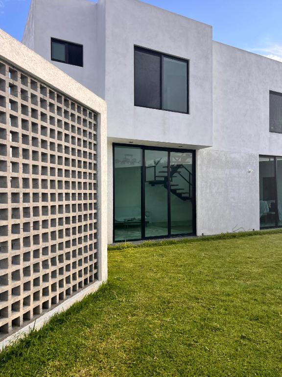 a facade of a building with windows and grass at Puerta Sevilla in Saltillo