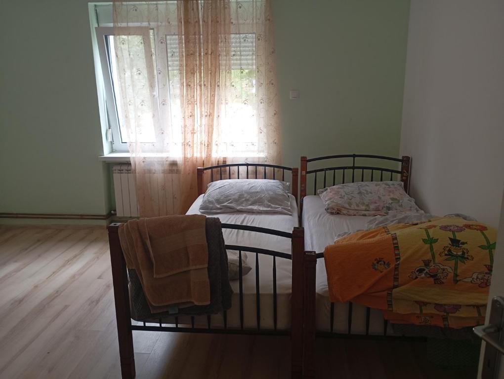 two twin beds in a room with a window at Padina-Kovacica in Padina