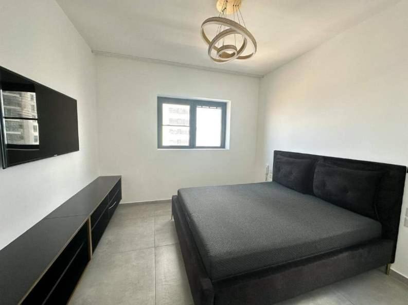 a bedroom with a bed and a black couch at O&O Group-Charming 4BR APT with Stellar Sea View in Bat Yam