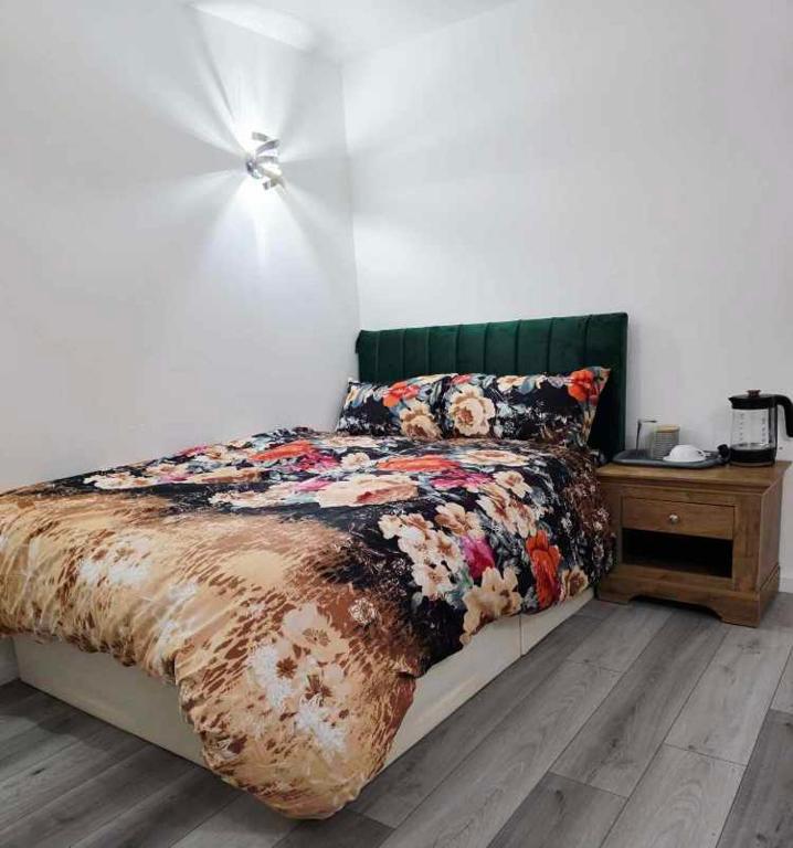 a bedroom with a bed and a night stand with a table at Oge's Apartment in Bradford