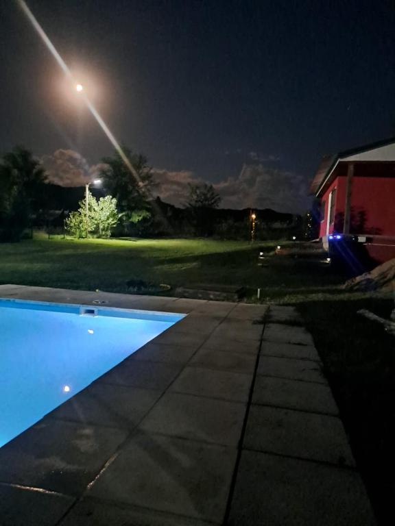 una piscina por la noche con luz de la calle en cabaña de montaña, en La Estancia