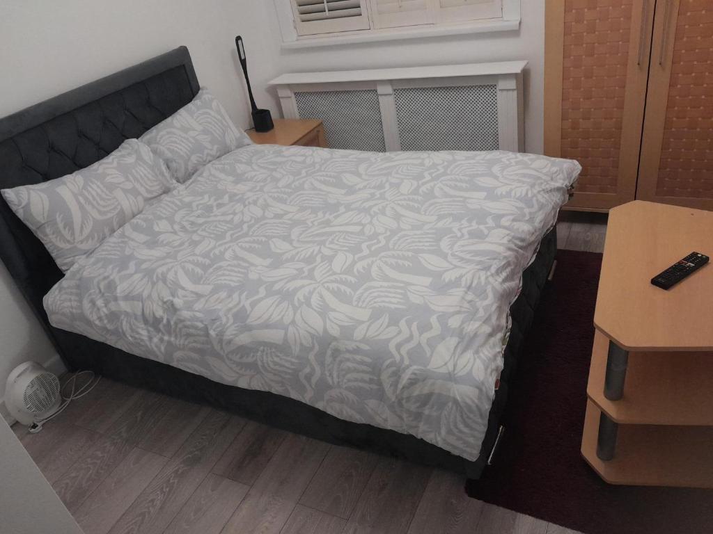 a bedroom with a bed with a white comforter at Cullen Sqaure in South Ockendon
