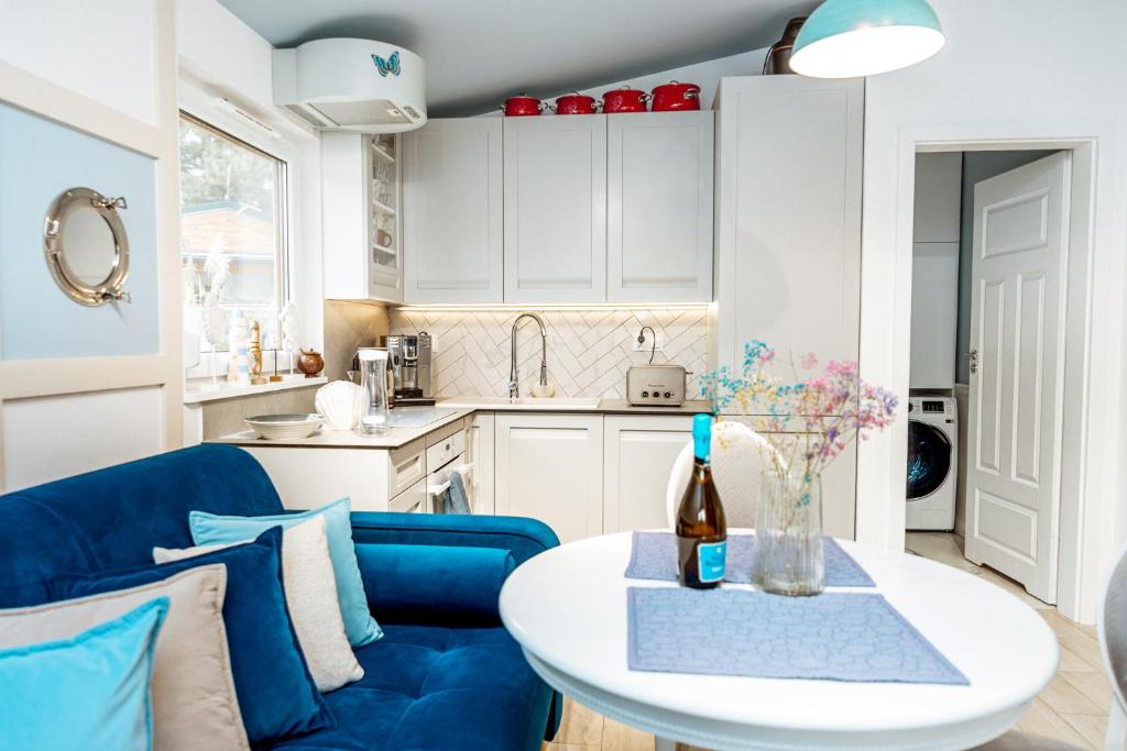 un soggiorno con un divano blu e un tavolo di Marina Lake House Boszkowo - całoroczny a Boszkowo-Letnisko