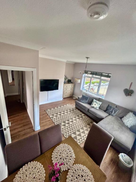 a living room with a couch and a table at Denzels Den Apartment 2 in Llandudno Junction