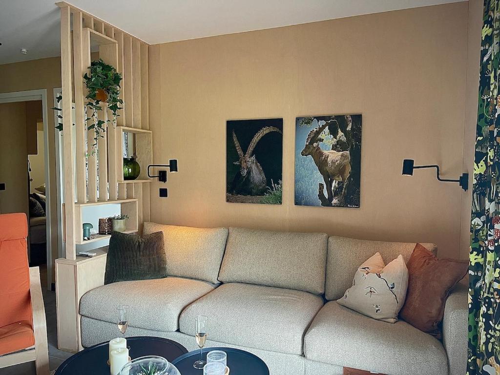sala de estar con sofá y pinturas en la pared en ELBA, Les Mazots de Kayla, en Les Houches