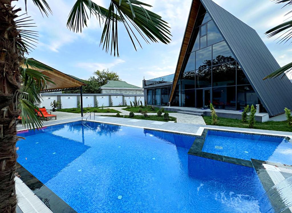 an image of a swimming pool in front of a building at Qafqaz Palm A-Frame Retreat in Gabala