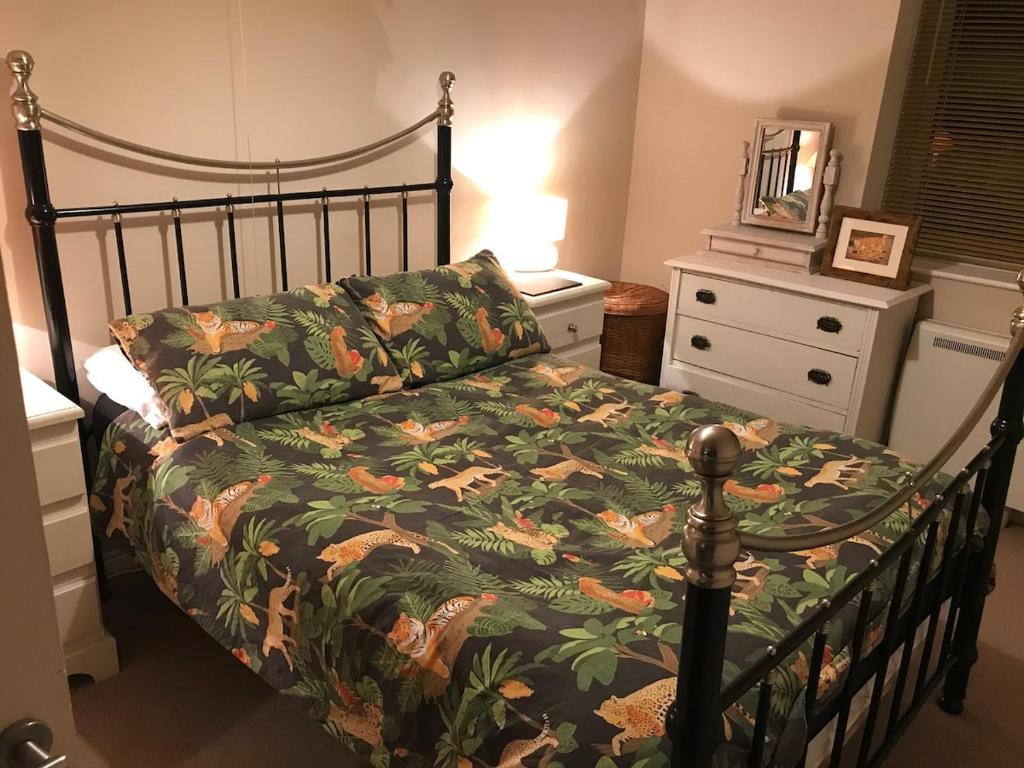 a bedroom with a bed with a floral comforter at 2 new bold lawns leamington spa in Moffat