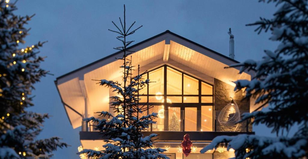 una casa di vetro con un albero di Natale in primo piano di be be Chalet - premium jacuzi - 2 bedrooms a Bukovel