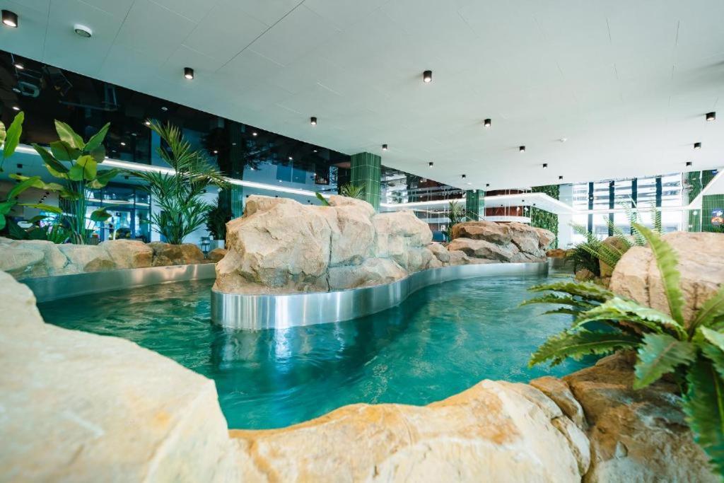 a large swimming pool in a building with rocks at Bel mare aqua 2 Aquapark in Międzyzdroje
