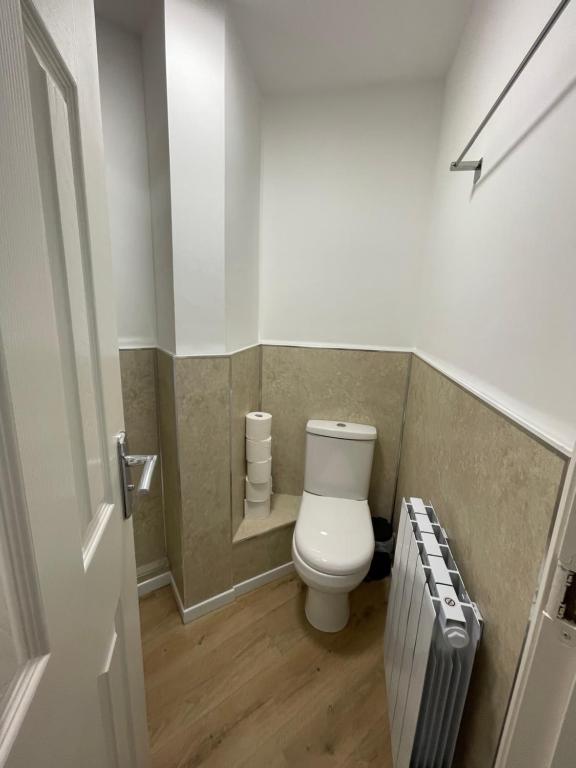 a small bathroom with a toilet and a radiator at Woodlands in Wythenshawe