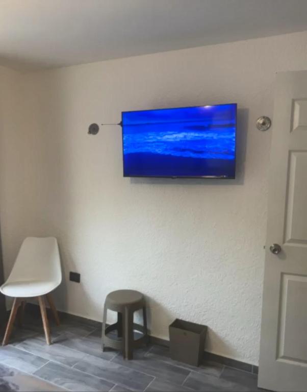 a flat screen tv hanging on a wall at Casa SaasNá, Departamento B, C y D in Cedro