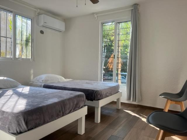 a bedroom with two beds and a window at Casa SaasNá, Departamento B, C y D in Cedro