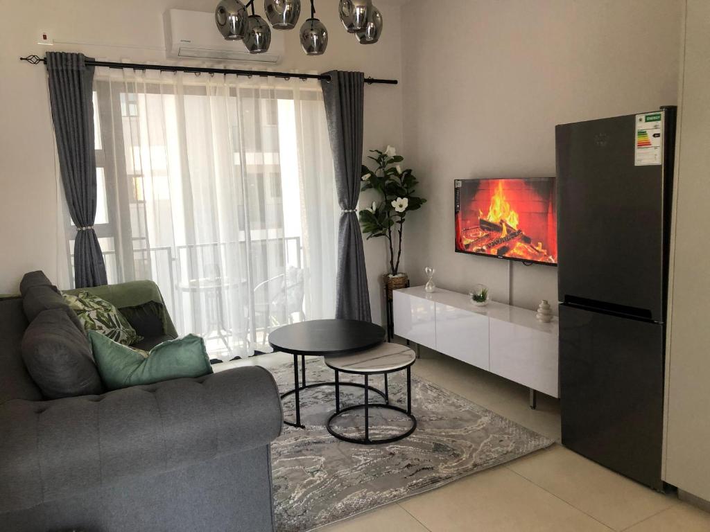 a living room with a couch and a table and a tv at Naledi Inn in Gaborone