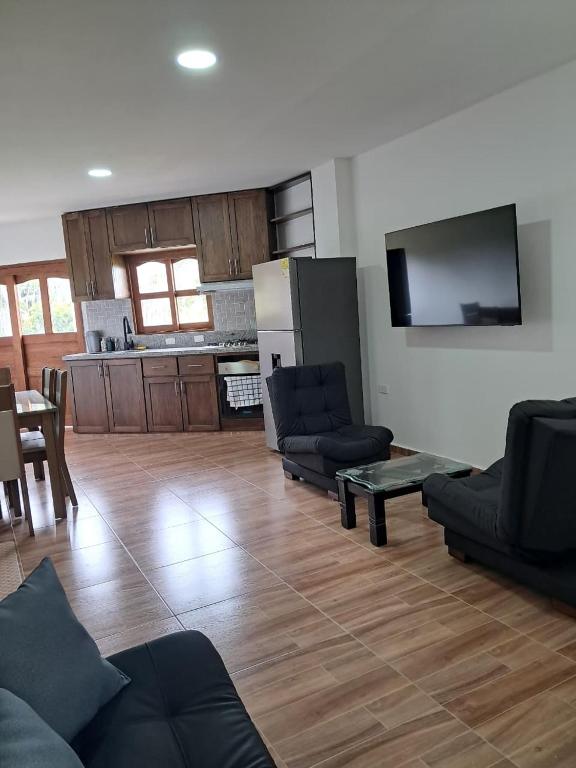a living room with couches and a table and a kitchen at jardin de flores Ant Apto 201 JW in Jardin