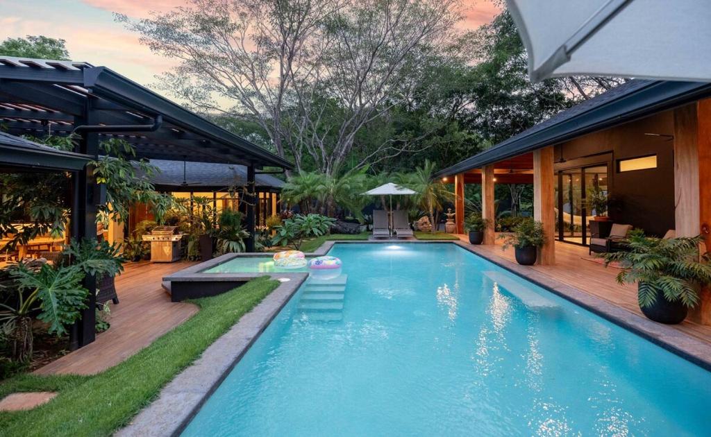 a swimming pool in front of a house at Balinese Inspired Luxury Villa in Playa Avellana