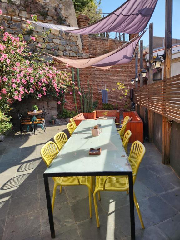 a table and chairs on a patio with flowers at La Casa Piola in Valparaíso