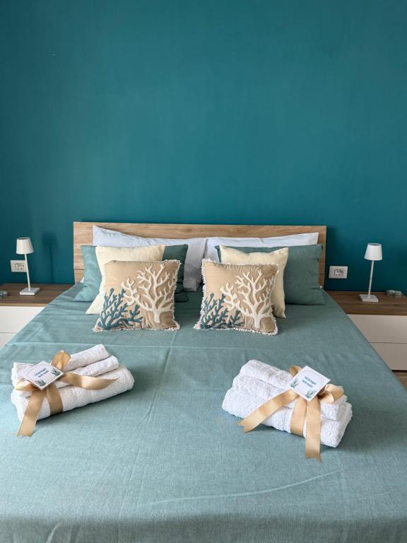a bed with two towels on it with a blue wall at Home Capri in Torre del Greco