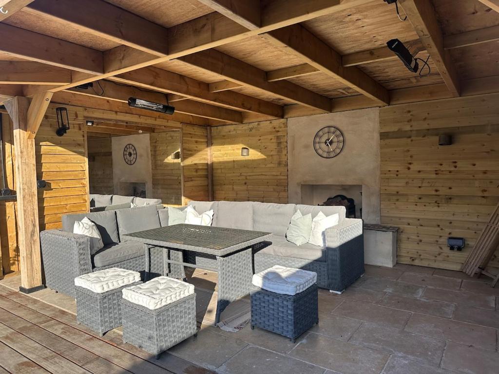 a patio with a table and a couch and a fireplace at High spec 4 bed Victorian house in Surbiton