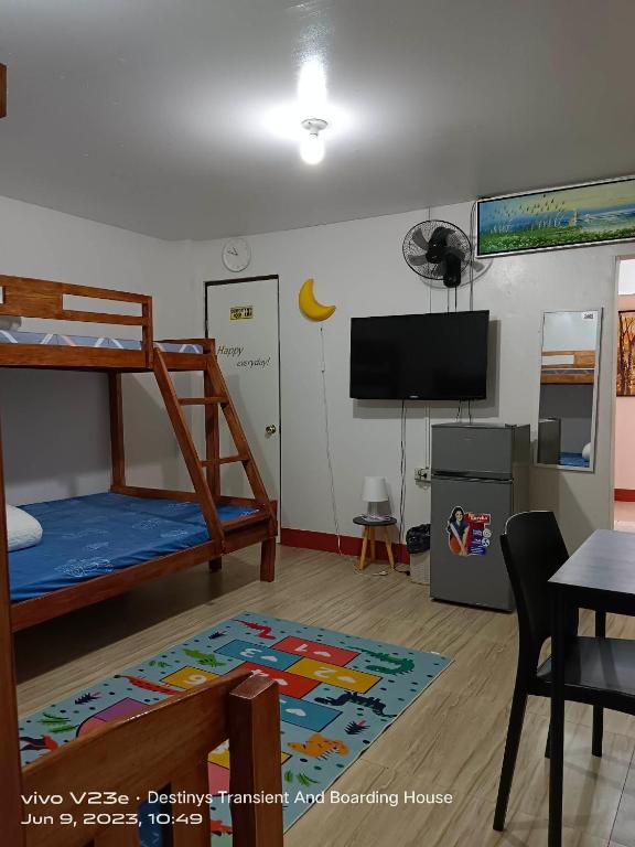 a bedroom with a bunk bed and a flat screen tv at Home by Destiny in Sampong
