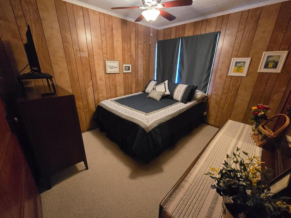 une chambre avec un lit et un ventilateur de plafond dans l'établissement Elena's Lake Cottage - A Cozy Lake Getaway, à Lake Geneva