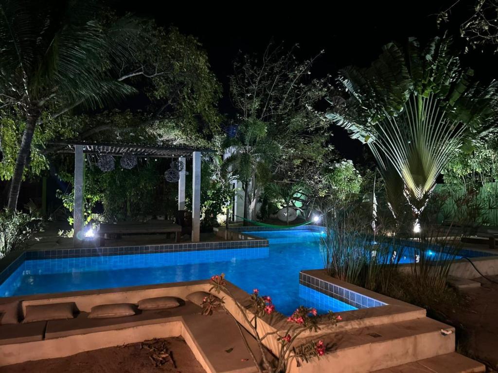 a swimming pool in a garden at night at Casa MCAYA in Fortim