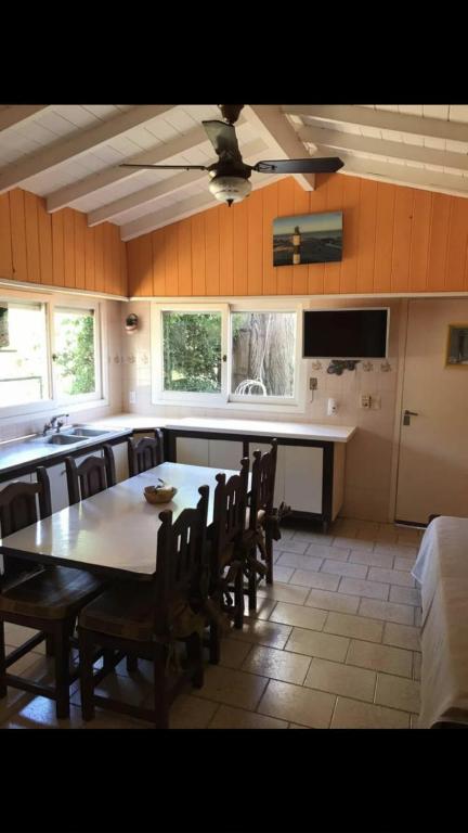 a kitchen with a table and chairs and a kitchen with a counter at La casita in Villa Gesell