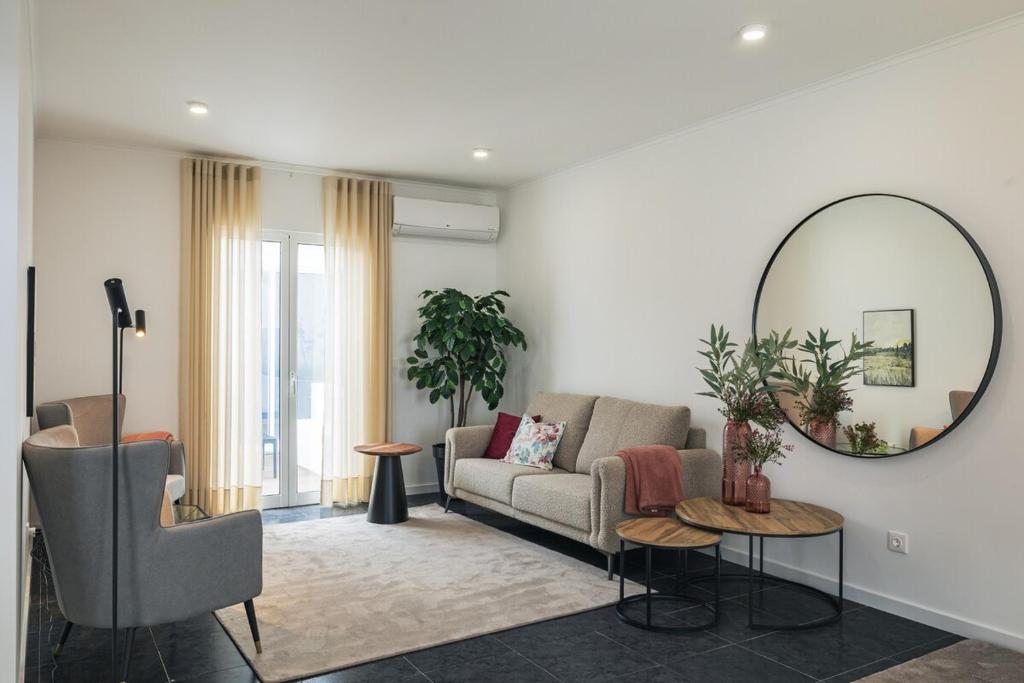 a living room with a couch and a mirror at Modern 3BR Home, AC in All Rooms, Walk to 2 Beaches, Private Patio, Washer & Dryer in Ribeira Grande