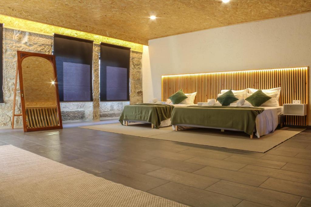 a bedroom with two beds with green and white pillows at Fonte da Rosa Guest House Central Studio in Belmonte