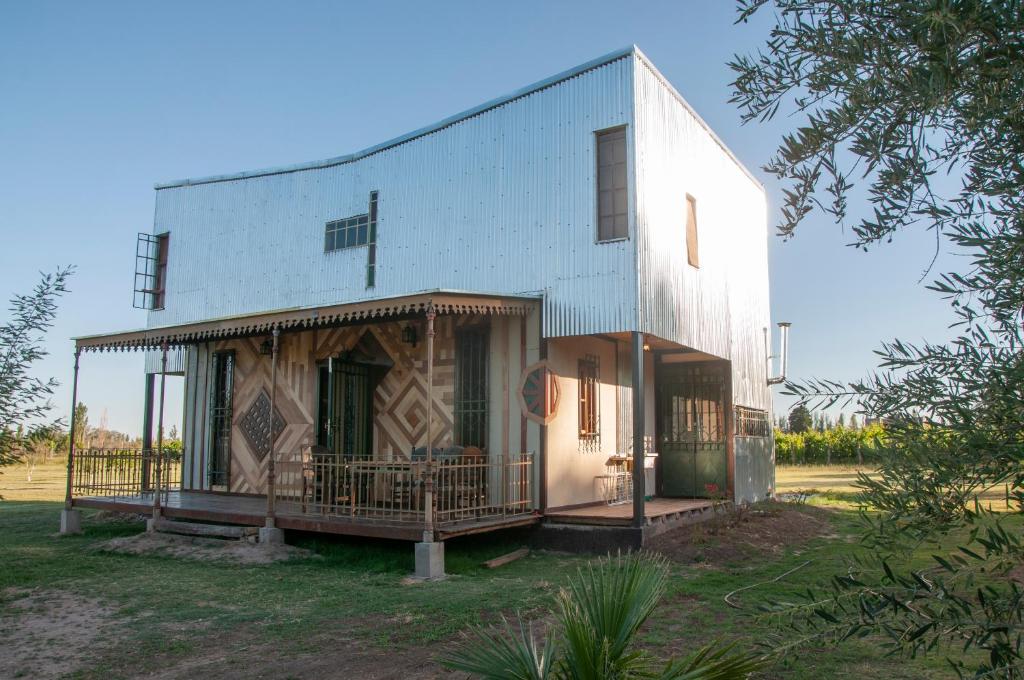 a white building with a porch on the side of it at Finca Bravi in Maipú