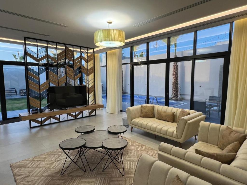 a living room with a couch and tables and a tv at اليجنت فيلا in Buraydah