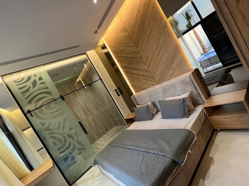 a small room with a bed and a glass door at اليجنت فيلا in Buraydah