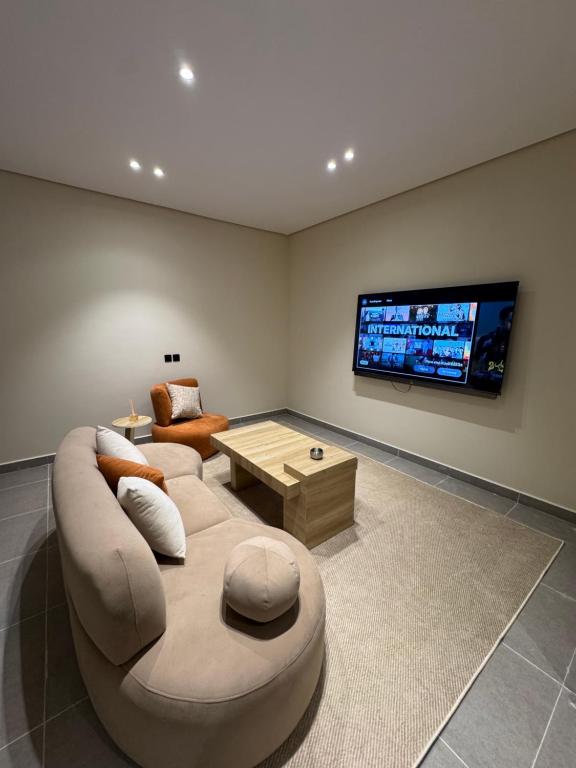 a living room with a couch and a tv at luxury apartment in AlUla